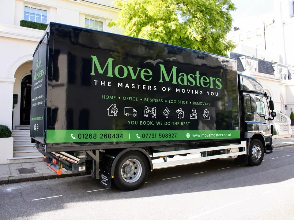 Black Move Masters removal lorry parked outside homes on a residential street