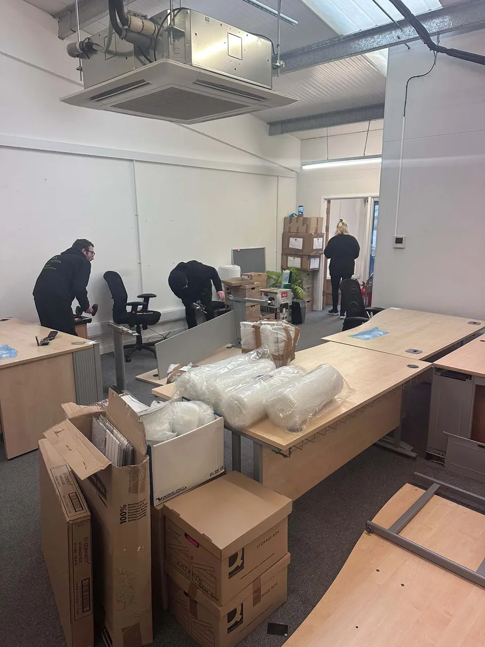 Office desks, chairs and packed boxes being prepared for a move